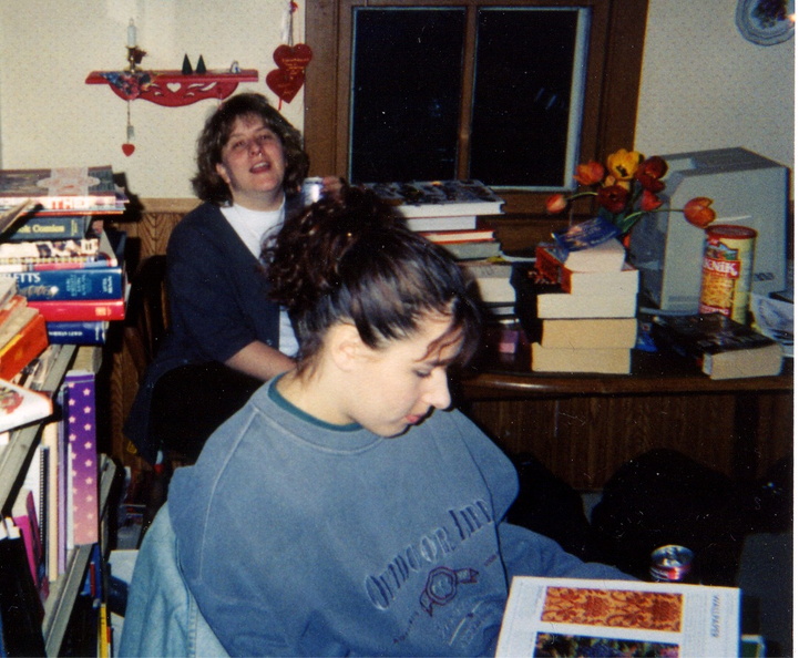 Janine laughing in background, while one of those neat people you meet at trivia looks at a resource (otherwise known as a book).